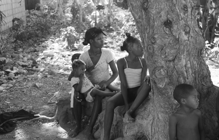 A woman and children staring into the distance.