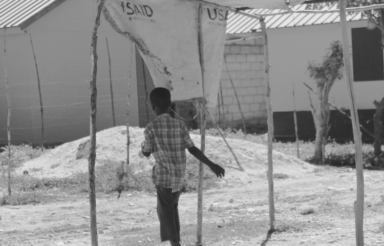 Young boy in a temporary shelter encampment constructed by USAID.