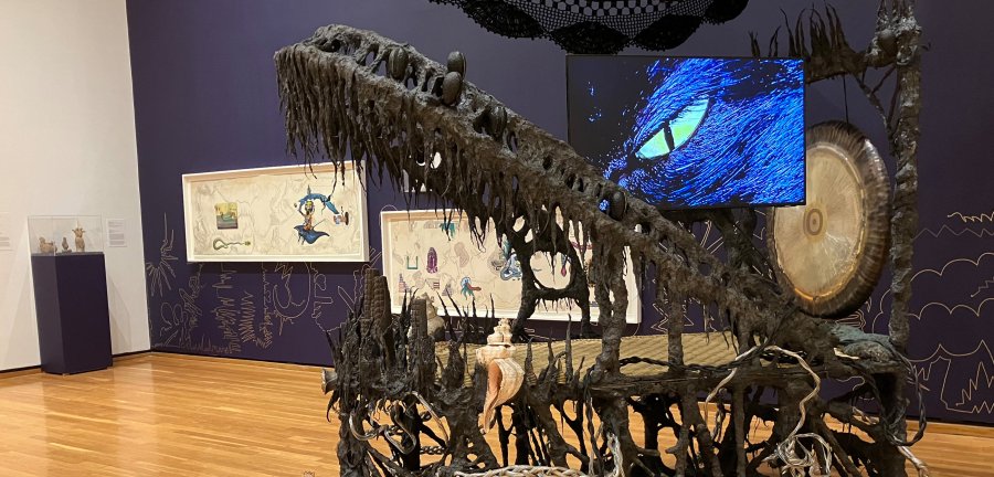 Gong, hammock, LCD TV, ceremonial ash, pyrite crystals, volcanic rock, steel, wood, cotton and glue mixture, plastic, loofah, and objects collected from a ritual retracing the artist’s original migration route.