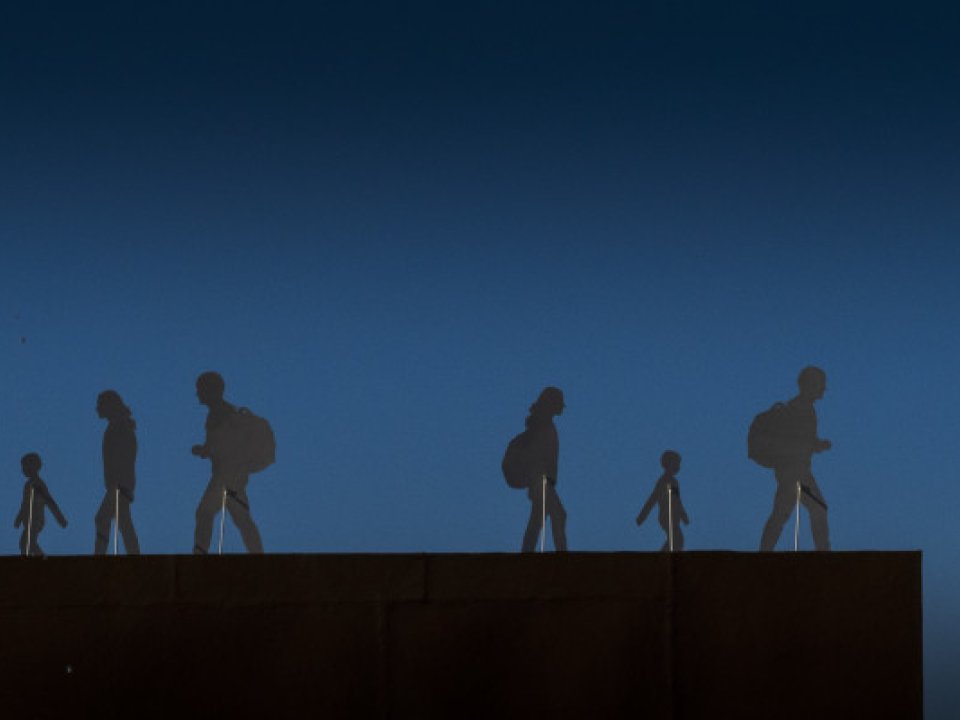 illustration of migrants walking on rooftop at night