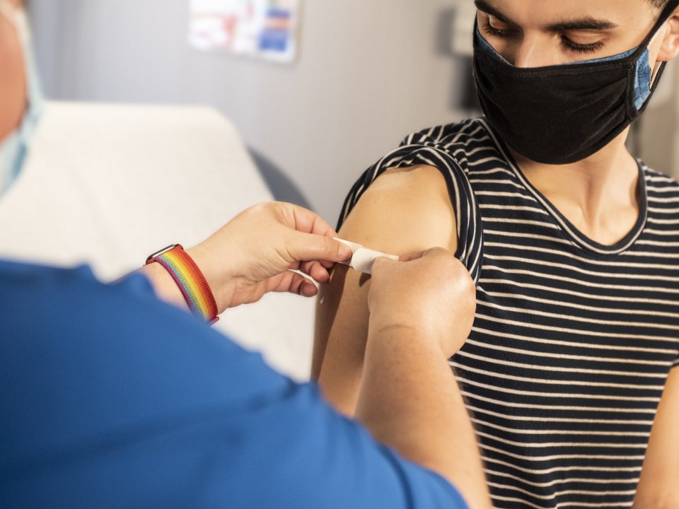 Doctor puts bandaid on vaccine patient's arm