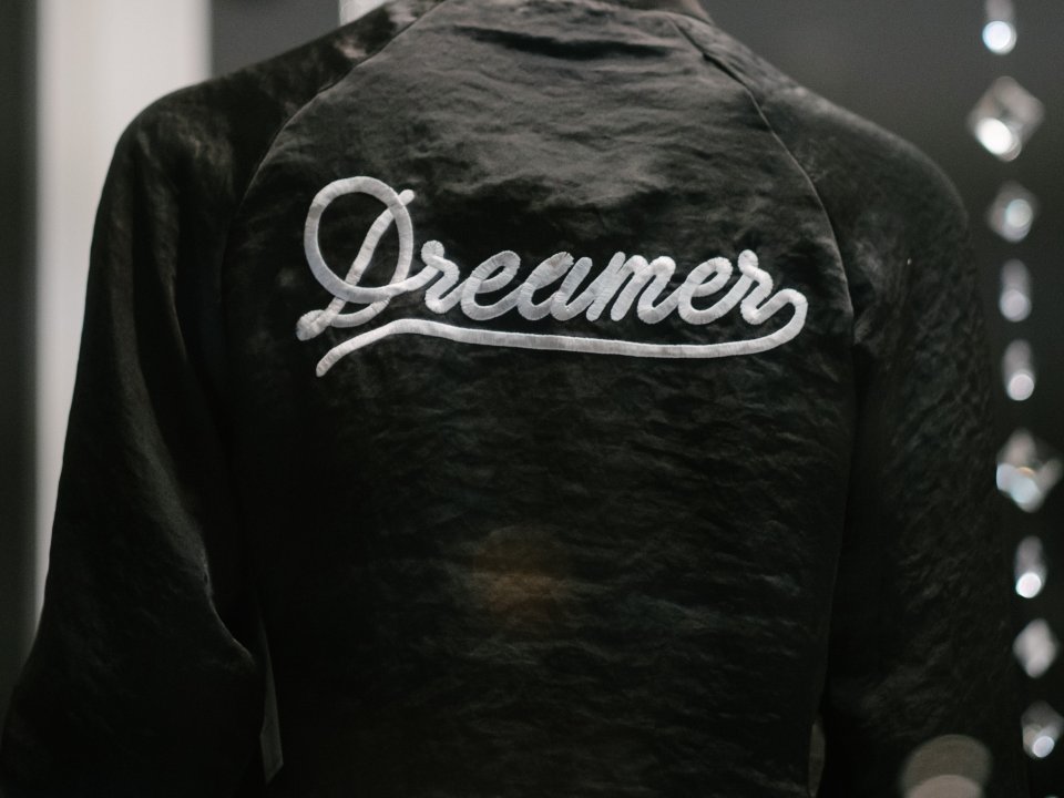Dark jacket with the word Dreamer embroidered in white