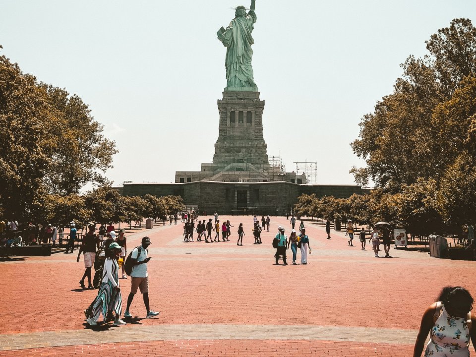 People walk around the base of the Statue of Liberty.