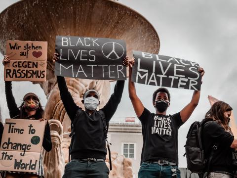 Protestors hold Black Lives Matter signs